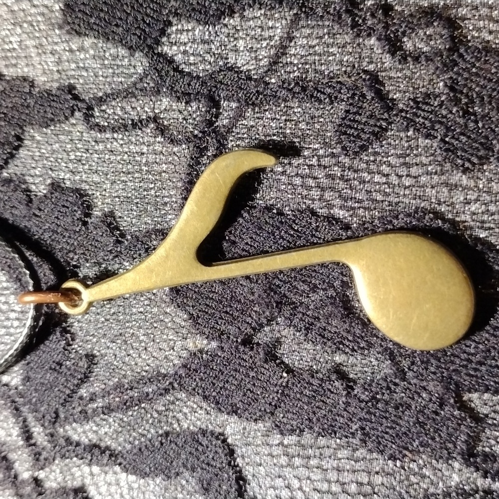 18-24" Black cotton necklace w/a brass colored music note pendant